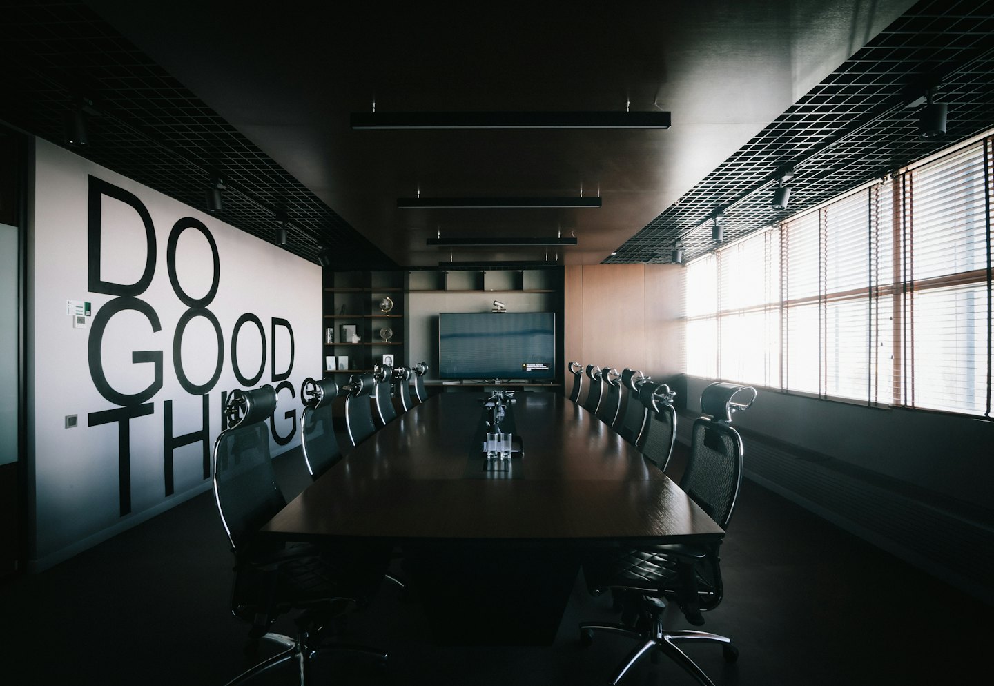Sala riunioni moderna con la scritta 'DO GOOD THINGS' sul muro.